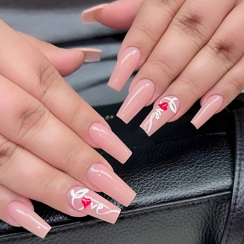 Long blush pink nails with white floral designs, from the Solar Nails gallery.