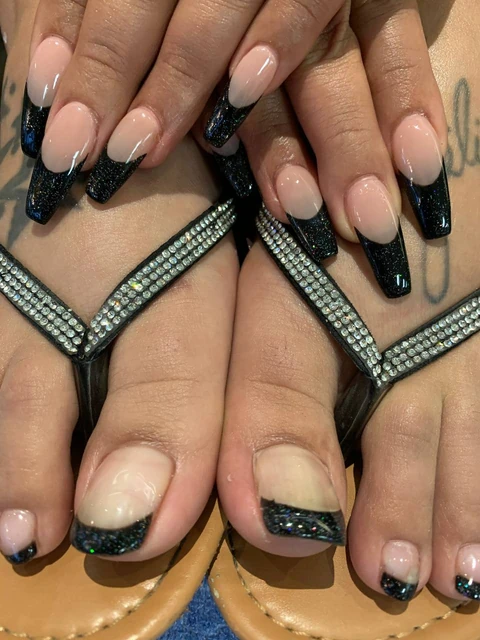 Coordinated black French manicure and pedicure from the Solar Nails gallery.
